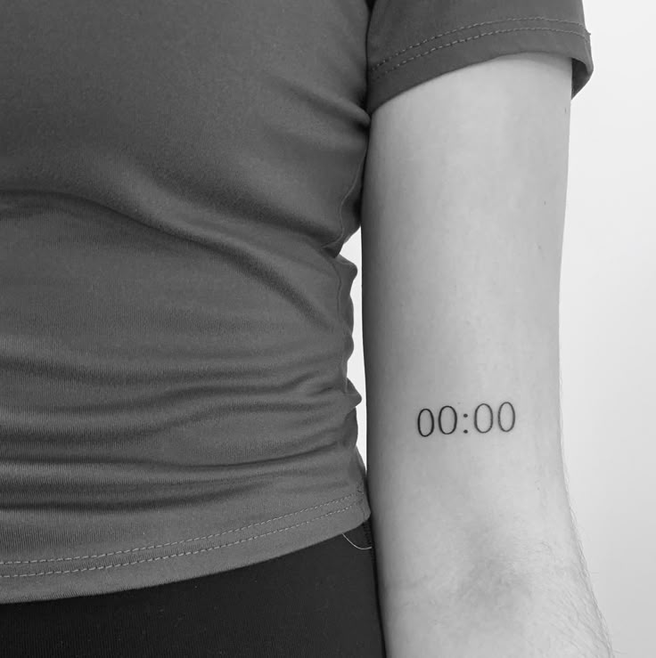 a woman with a tattoo on her arm that reads 000 and has the numbers behind it