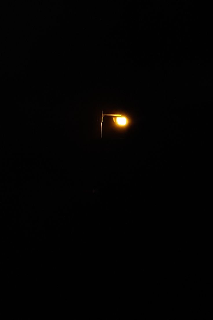 a street light in the dark with no one on it's head or arms