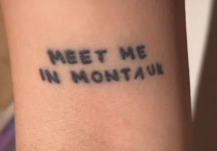 a tattoo that reads meet me in montaun on the arm and is written with black ink