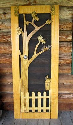 a wooden door with a tree and bird on it