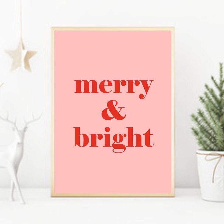 a pink poster with the words merry and bright on it next to a potted plant