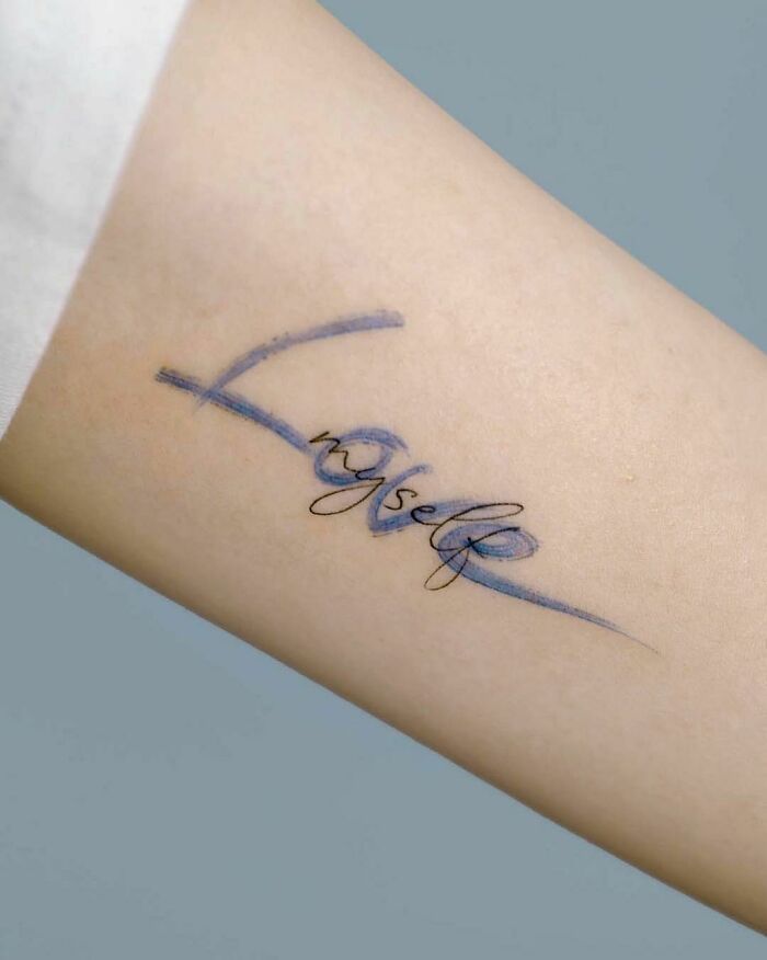 the word love is written in cursive writing on a woman's arm