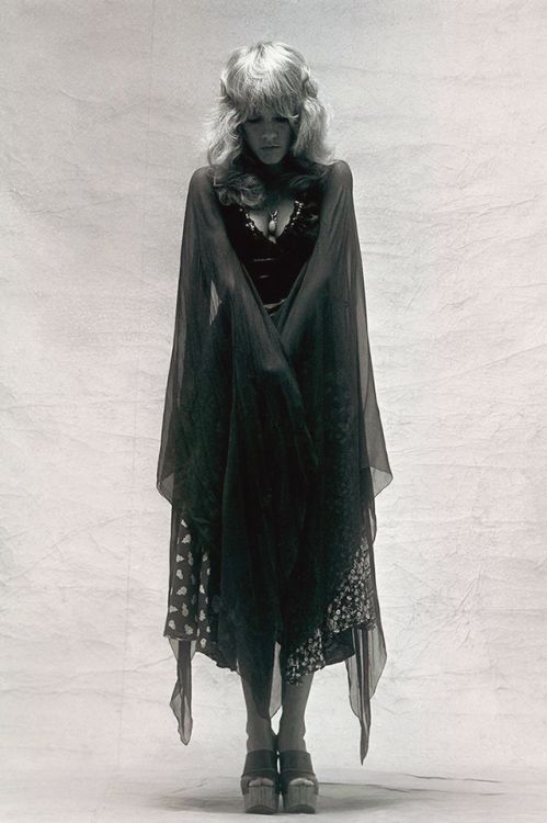 black and white photograph of a woman wearing a cape