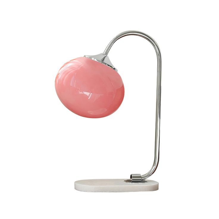 a pink table lamp on a white base with a silver metal arm and light bulb