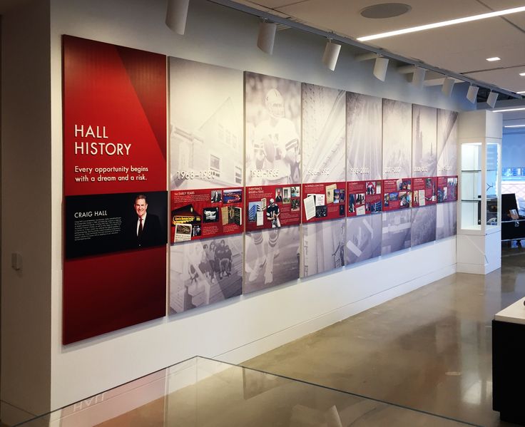 an office lobby with posters on the wall and desks in front of it,