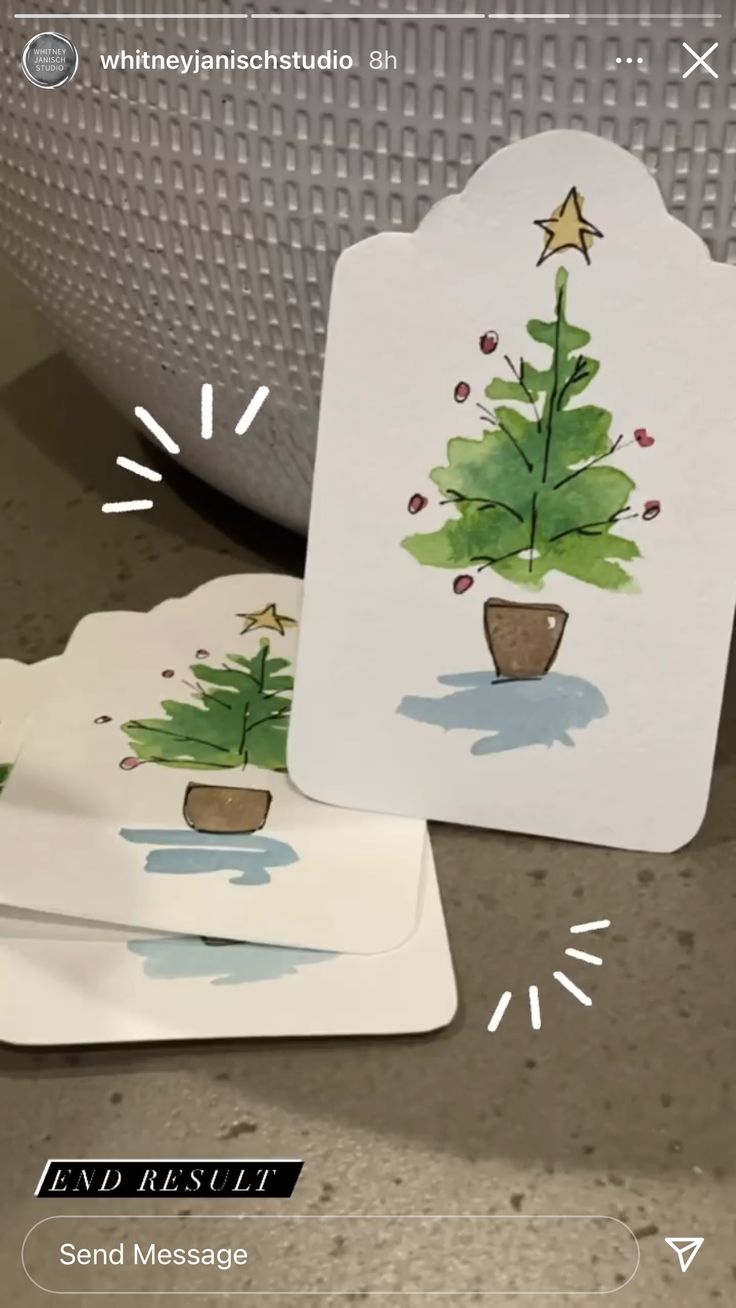 two tags with christmas trees on them sitting next to a potted plant and the tag says send message