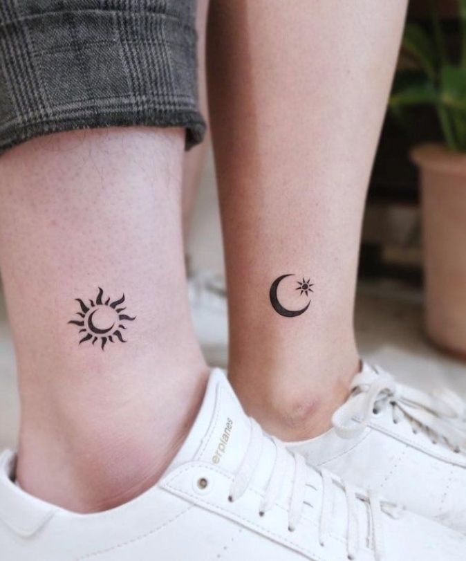 two people with matching tattoos on their legs, one has a sun and the other has a crescent