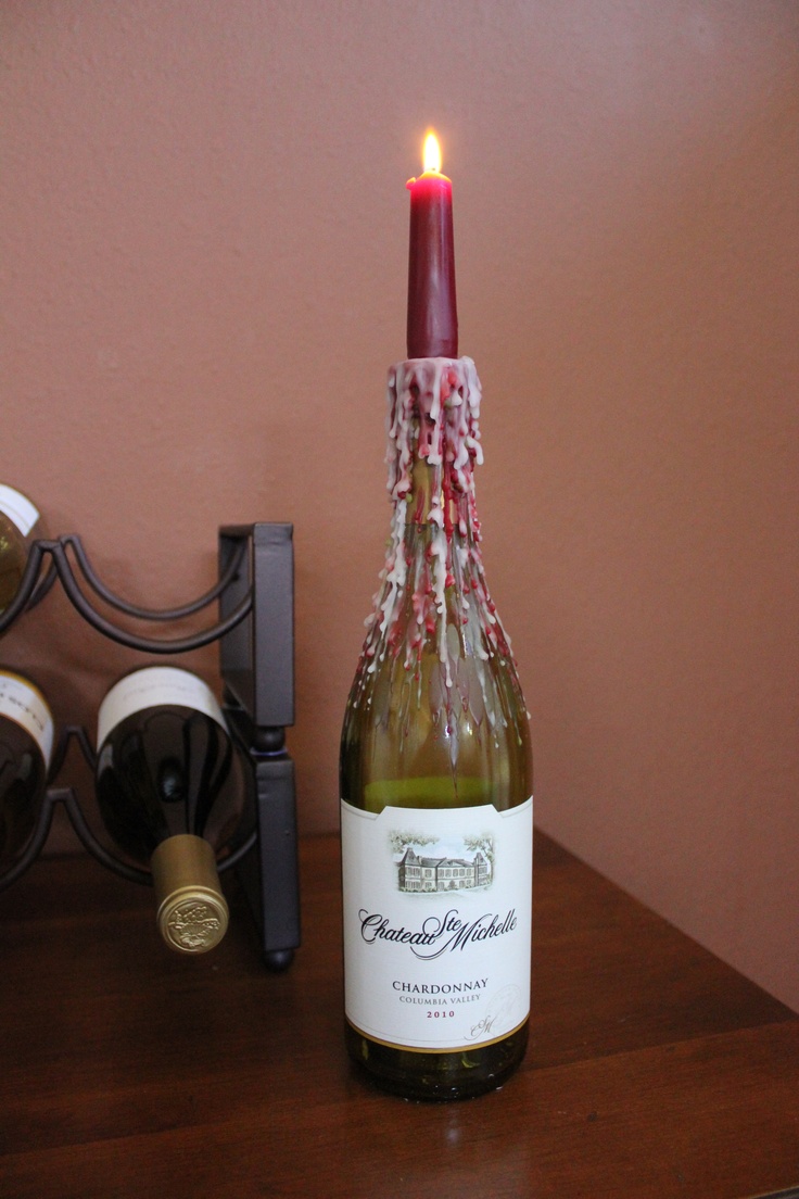 a bottle of wine sitting on top of a wooden table next to a candle holder