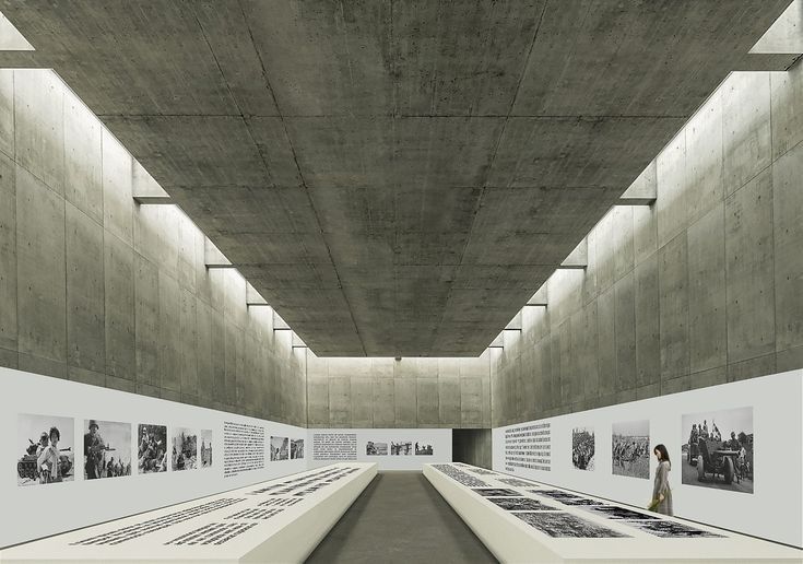 the interior of an art gallery with concrete walls and flooring that are lined with photographs