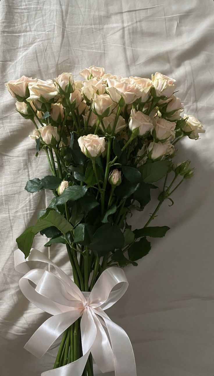 a bouquet of white roses tied with a ribbon