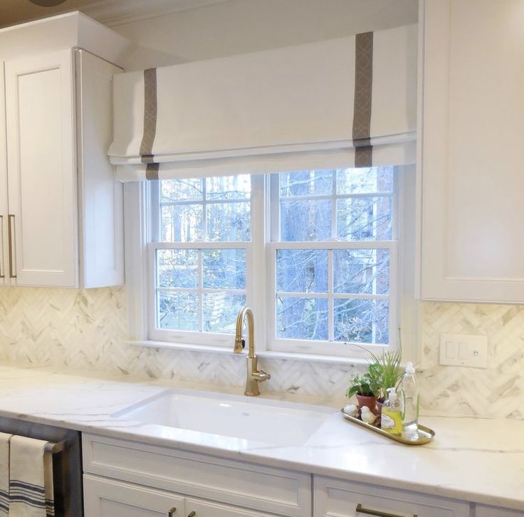 a kitchen with white cabinets and marble counter tops, along with a dishwasher