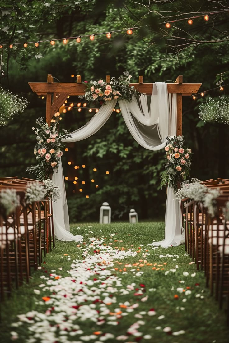 an outdoor ceremony with flowers and greenery