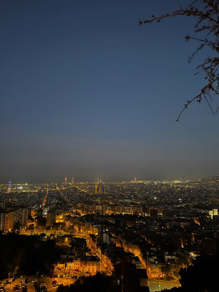 the city is lit up at night with lights shining on it's buildings and trees