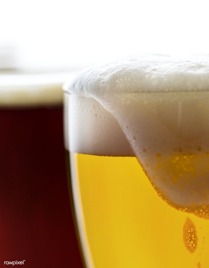 a glass filled with beer sitting on top of a table