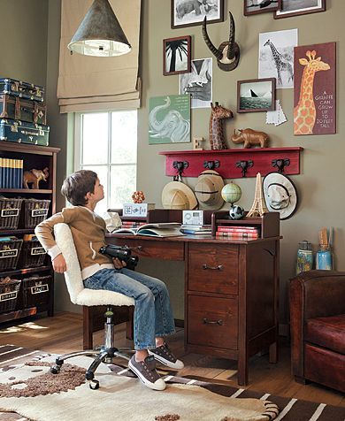 a woman sitting at a desk in front of a book shelf with books on it