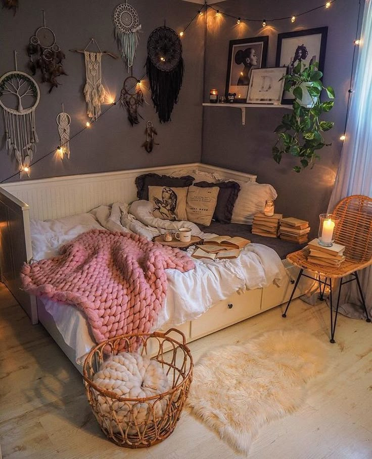 a bed with blankets, pillows and lights in a room that is decorated for christmas