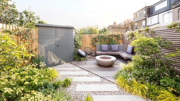 an outdoor living area is shown in this backyard garden with seating and plants on the ground