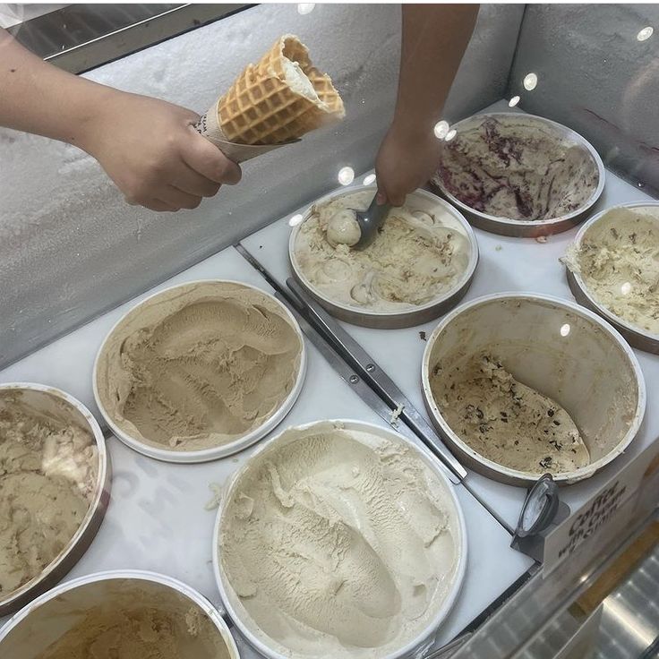 a person scooping ice cream into bowls