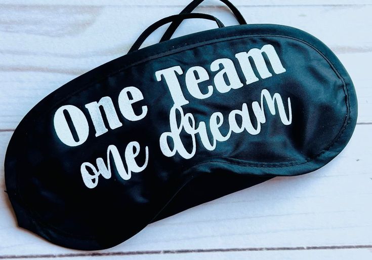 one team, one dream black eye mask with white writing on the front and bottom