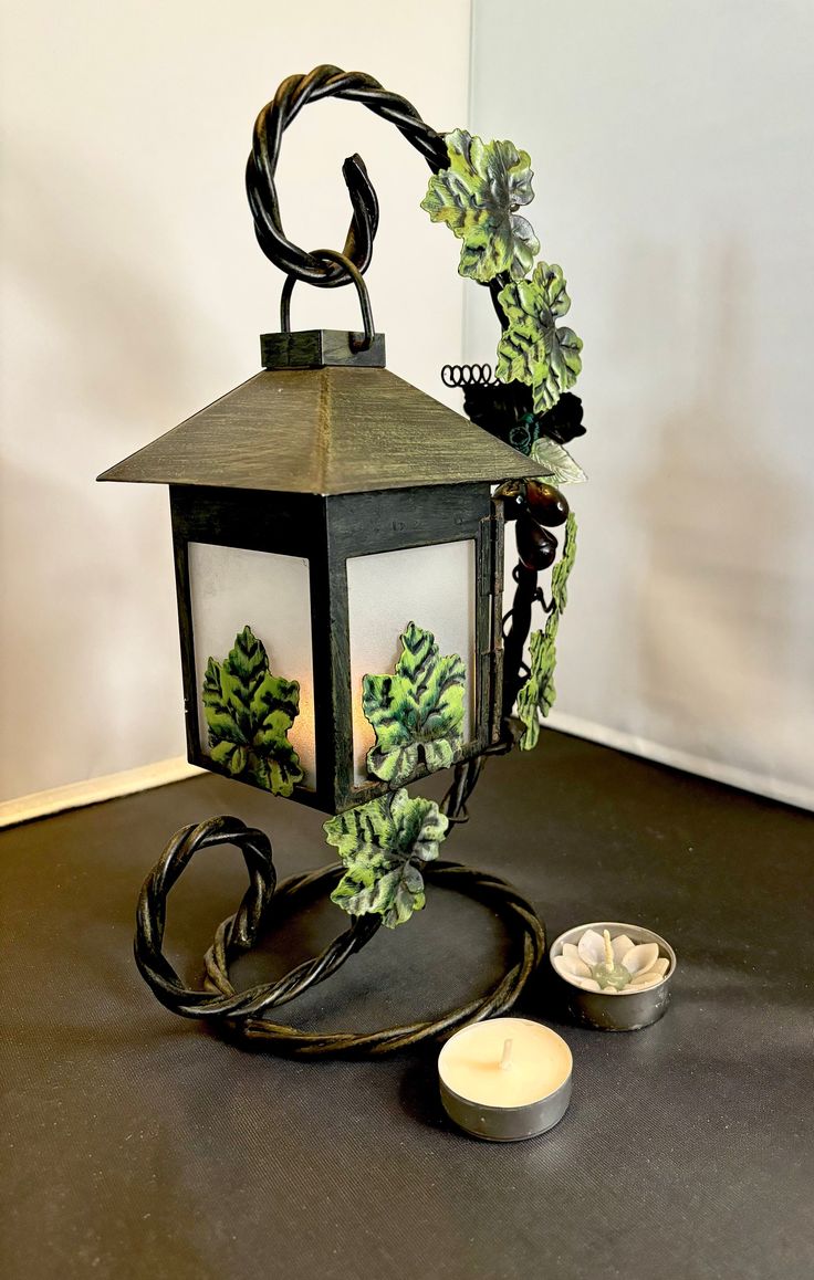 a lit up lantern sitting on top of a table next to a bowl and candle