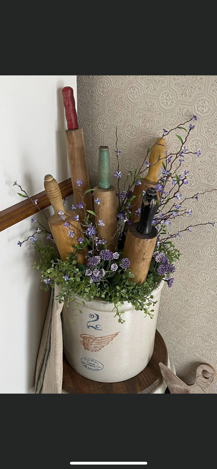 there is a potted plant with flowers in it on the shelf next to a wall