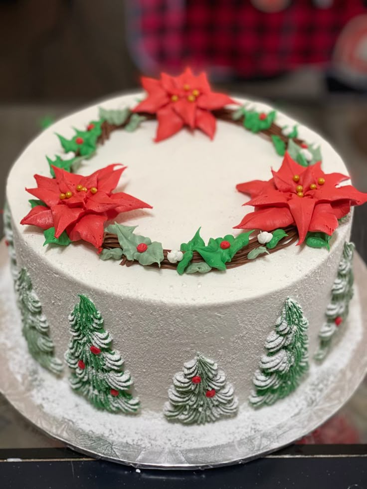 a decorated christmas cake with poinsettis on top