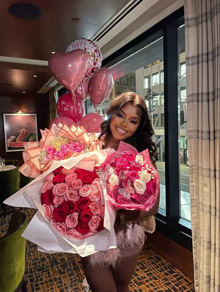 a woman holding a bouquet of roses in front of a window with the words love written on it