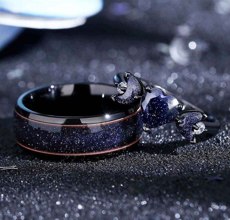 two rings with blue and black glitters on them, one is shaped like a cat