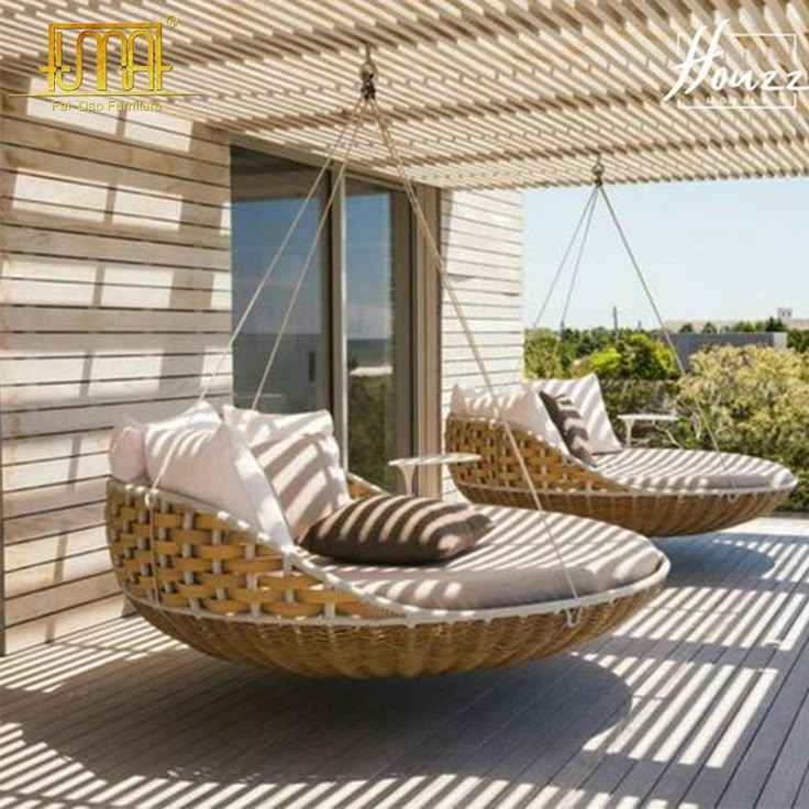 two wicker chairs sitting on top of a wooden deck next to an open window