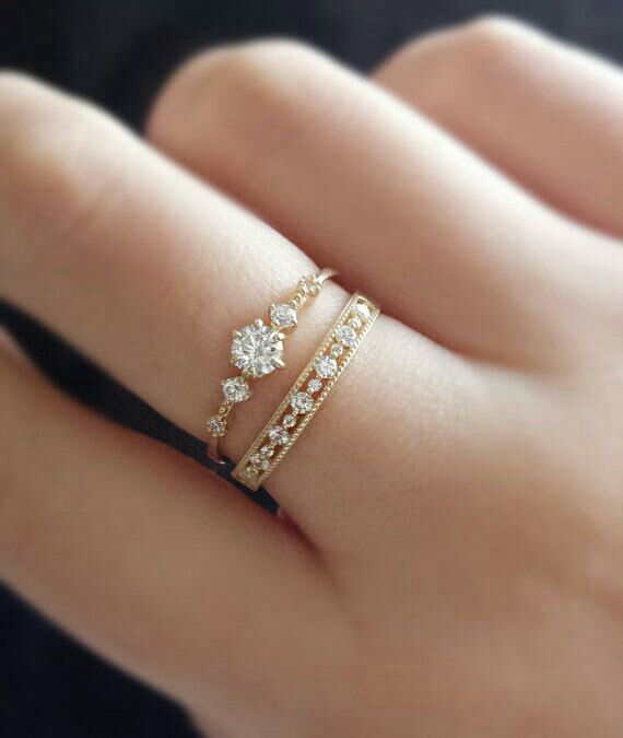 a woman's hand with two rings on it and one is holding the other