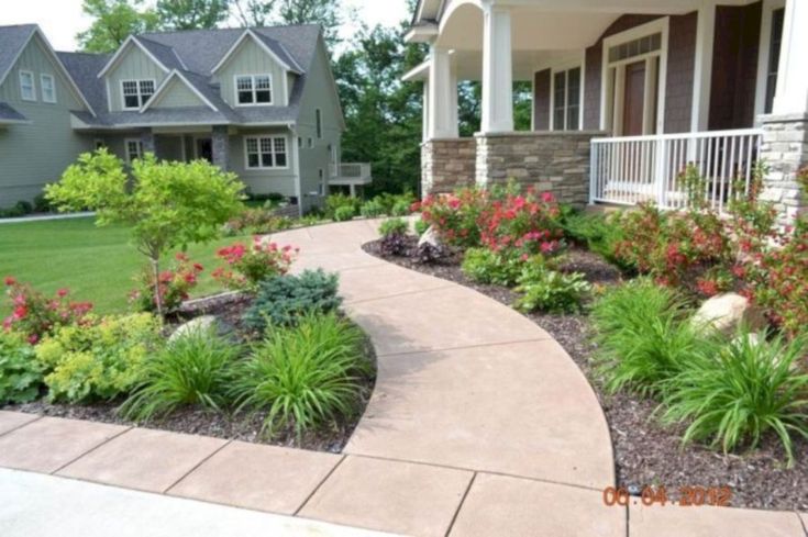 a house with landscaping and flowers in the front yard