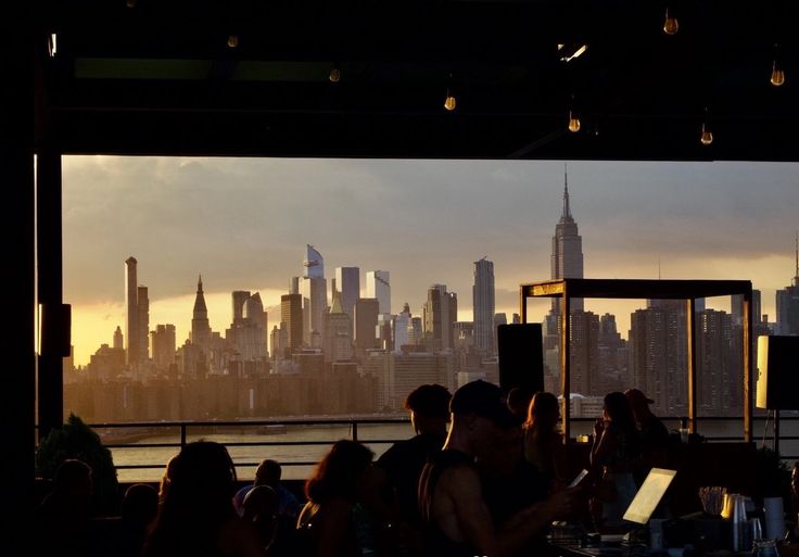 a group of people sitting at a table in front of a city skyline