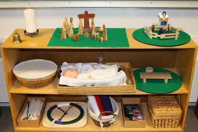 a baby is laying in a crib surrounded by other toys and decorations on a shelf