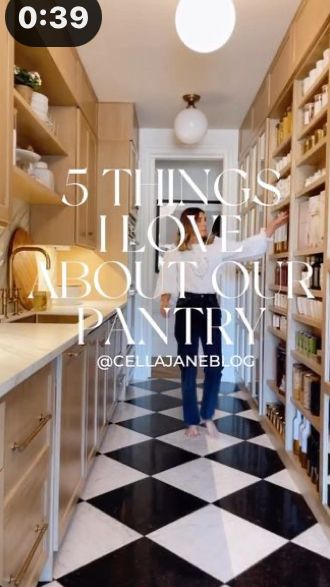 a woman standing in the middle of a kitchen with shelves full of food and other items