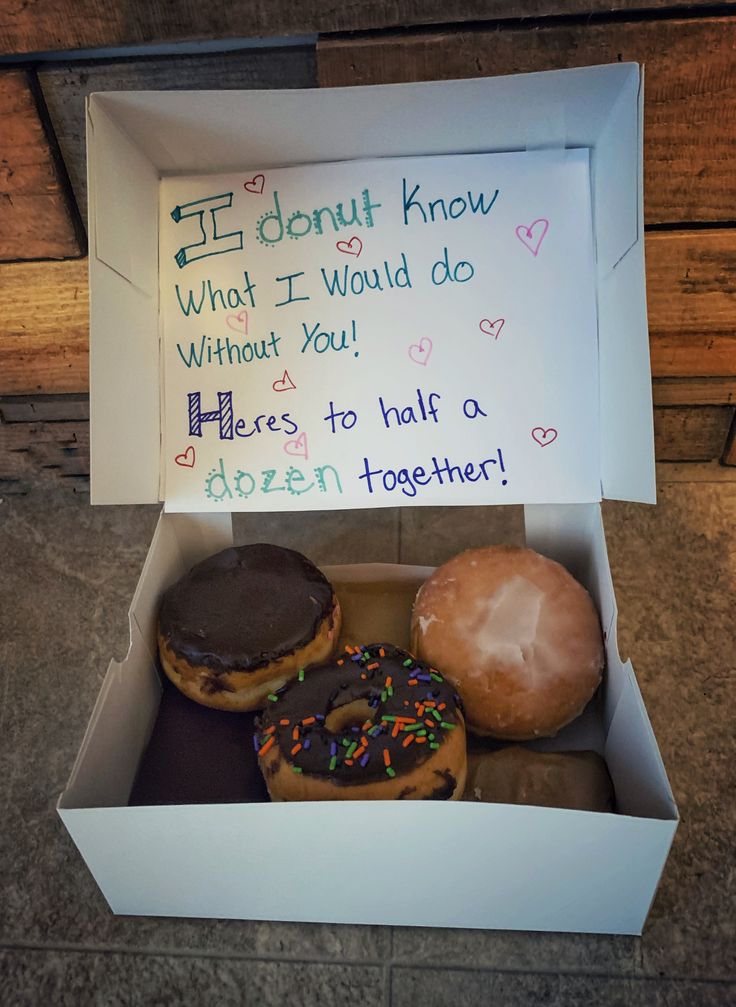 three donuts in a box with writing on them