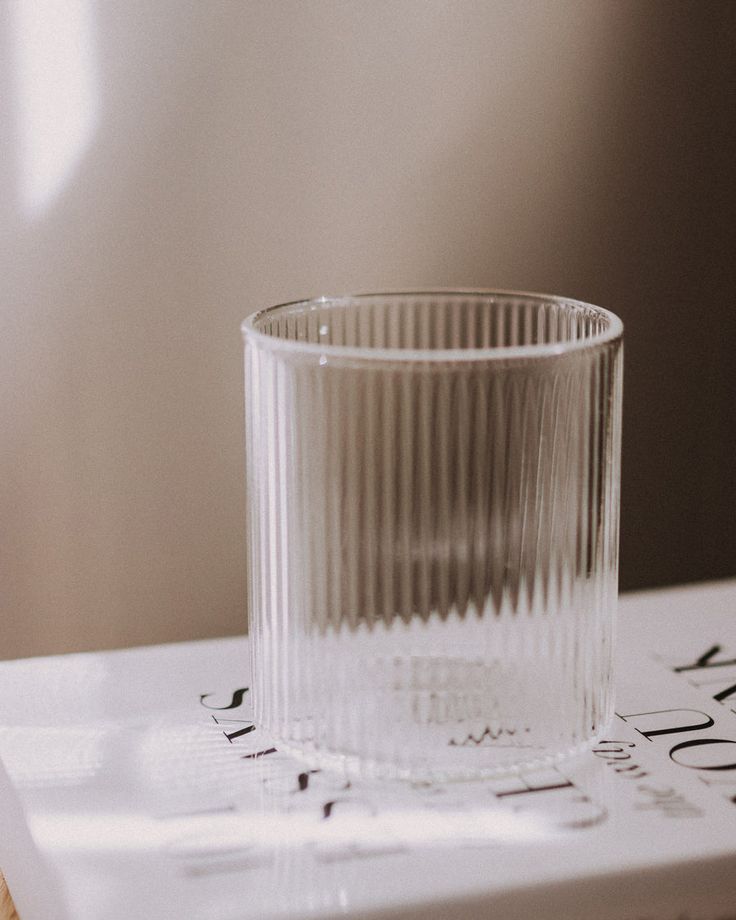 a clear glass sitting on top of a book