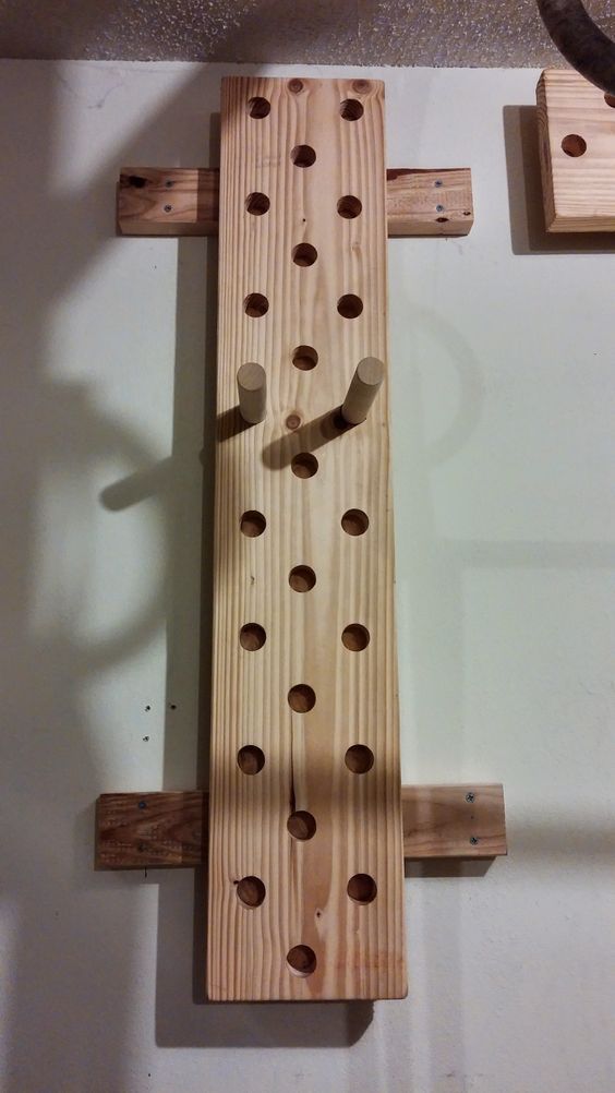 a wooden peg board with holes in the middle and two pieces of wood attached to it