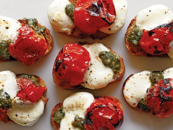 small appetizers with tomatoes and mozzarella are arranged on a white plate