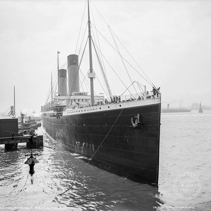 an old photo of a large ship in the water with people standing on it's side