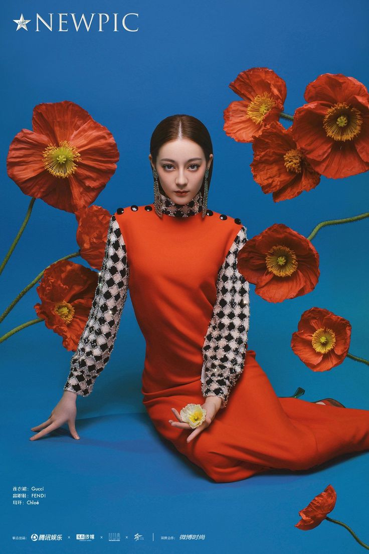 a woman in an orange dress is sitting on the cover of a magazine with red flowers