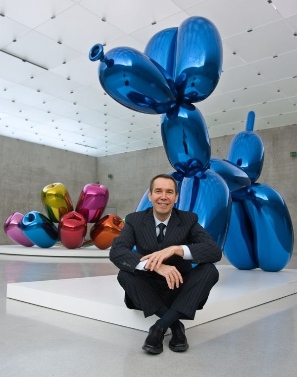 a man is sitting in front of some colorful sculptures