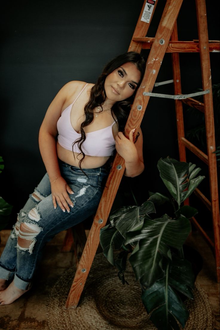 a woman leaning against a wooden ladder