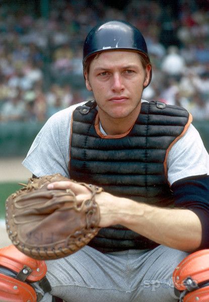 a baseball player sitting in the outfield with his catchers mitt