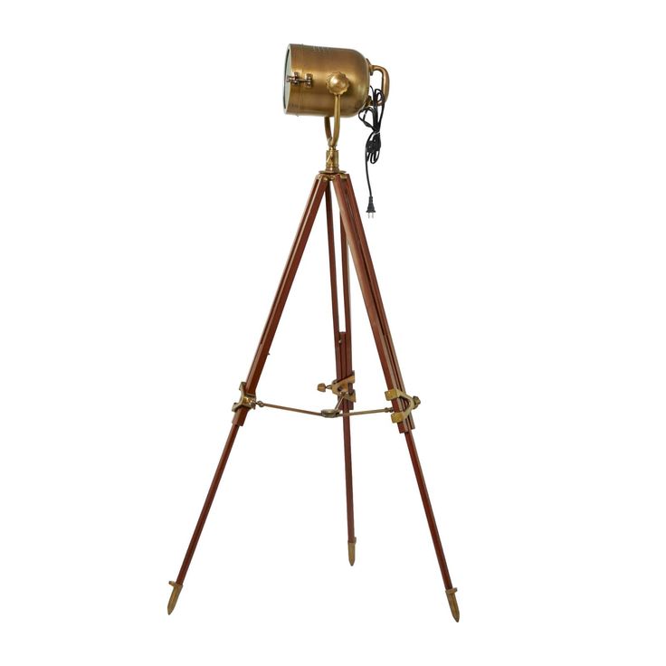 an antique brass tripod lamp on a white background