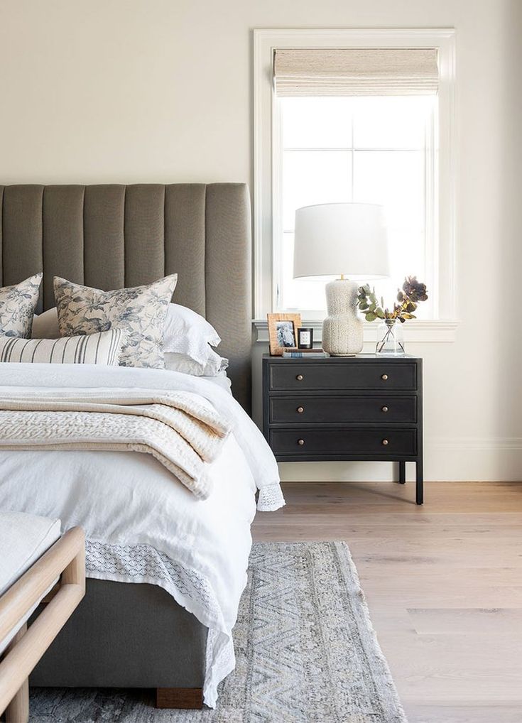 a bedroom with a bed, dresser and window