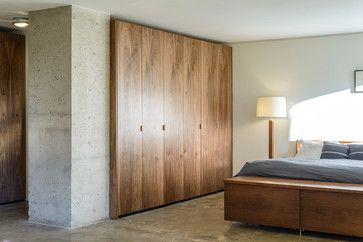 a bedroom with a bed and wooden closets