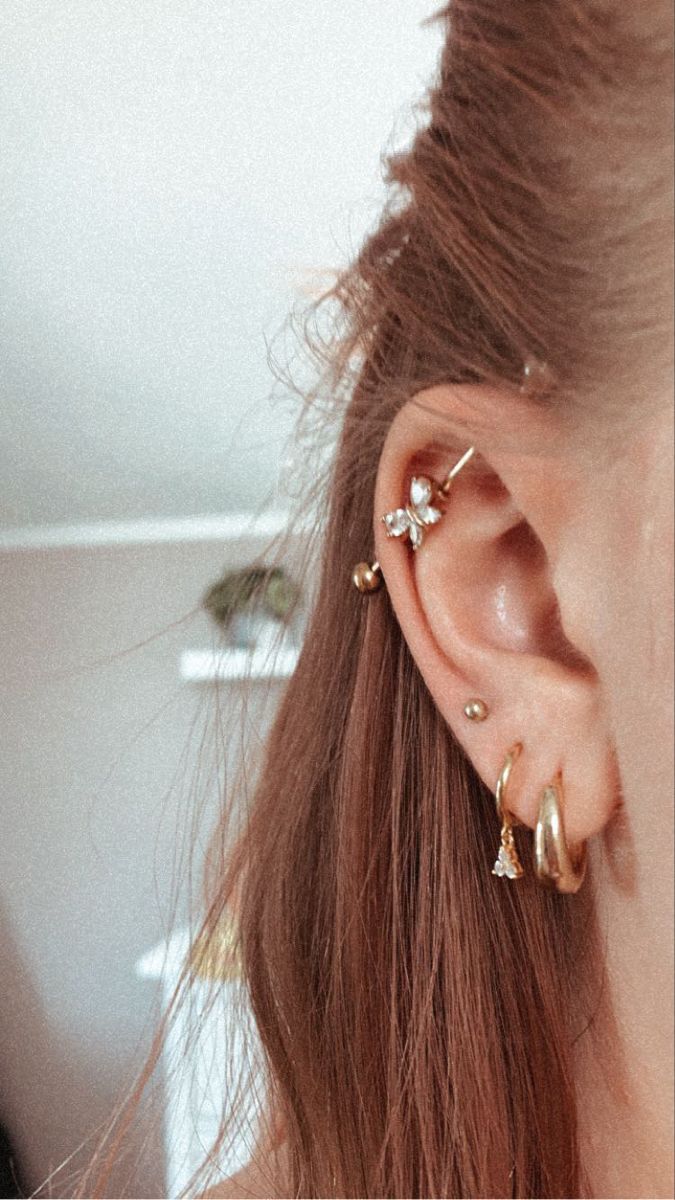 a close up of a person's ear with two piercings on top of it