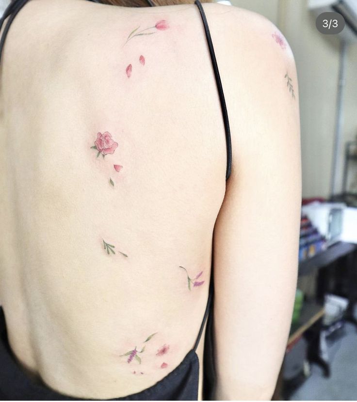 the back of a woman's body with pink flowers on her upper and lower back