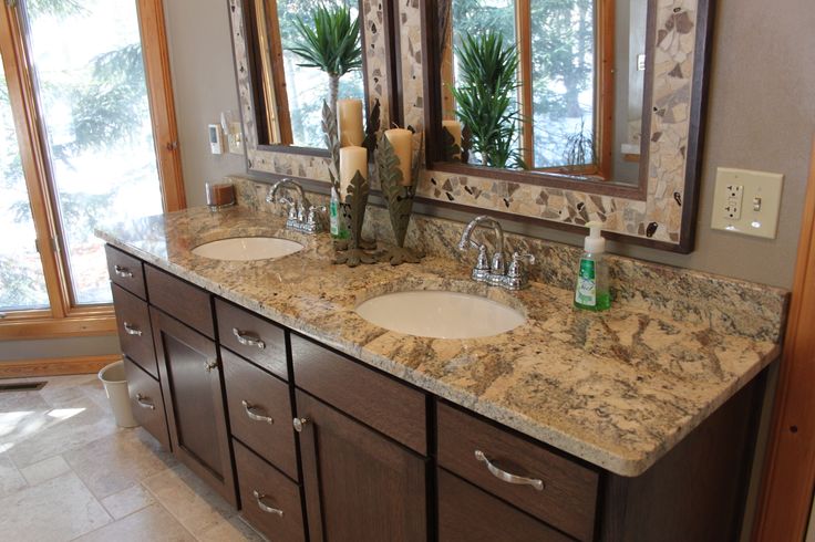 a bathroom with double sinks and mirrors in the middle of it's countertop