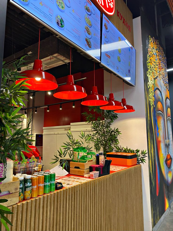 the interior of a fast food restaurant with red lights hanging from it's ceiling